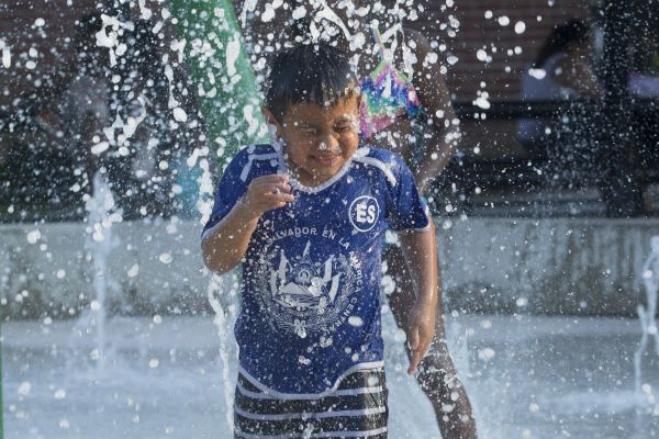 Kind zoekt verkoeling in fontein tijdens hitte