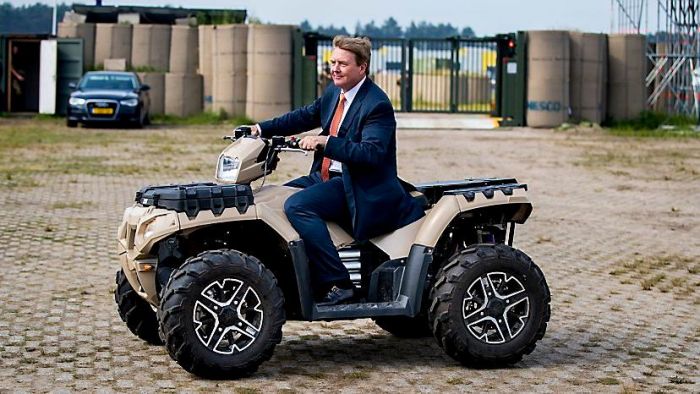 Koning rijdt rondje op een quad